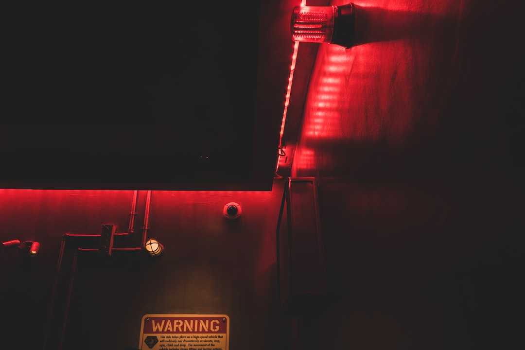 A dark room lit by a red warning light and sign